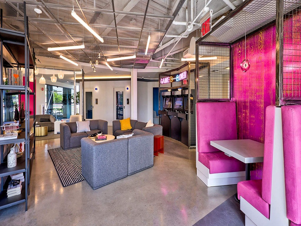 a lobby with couches and chairs and a pink divider